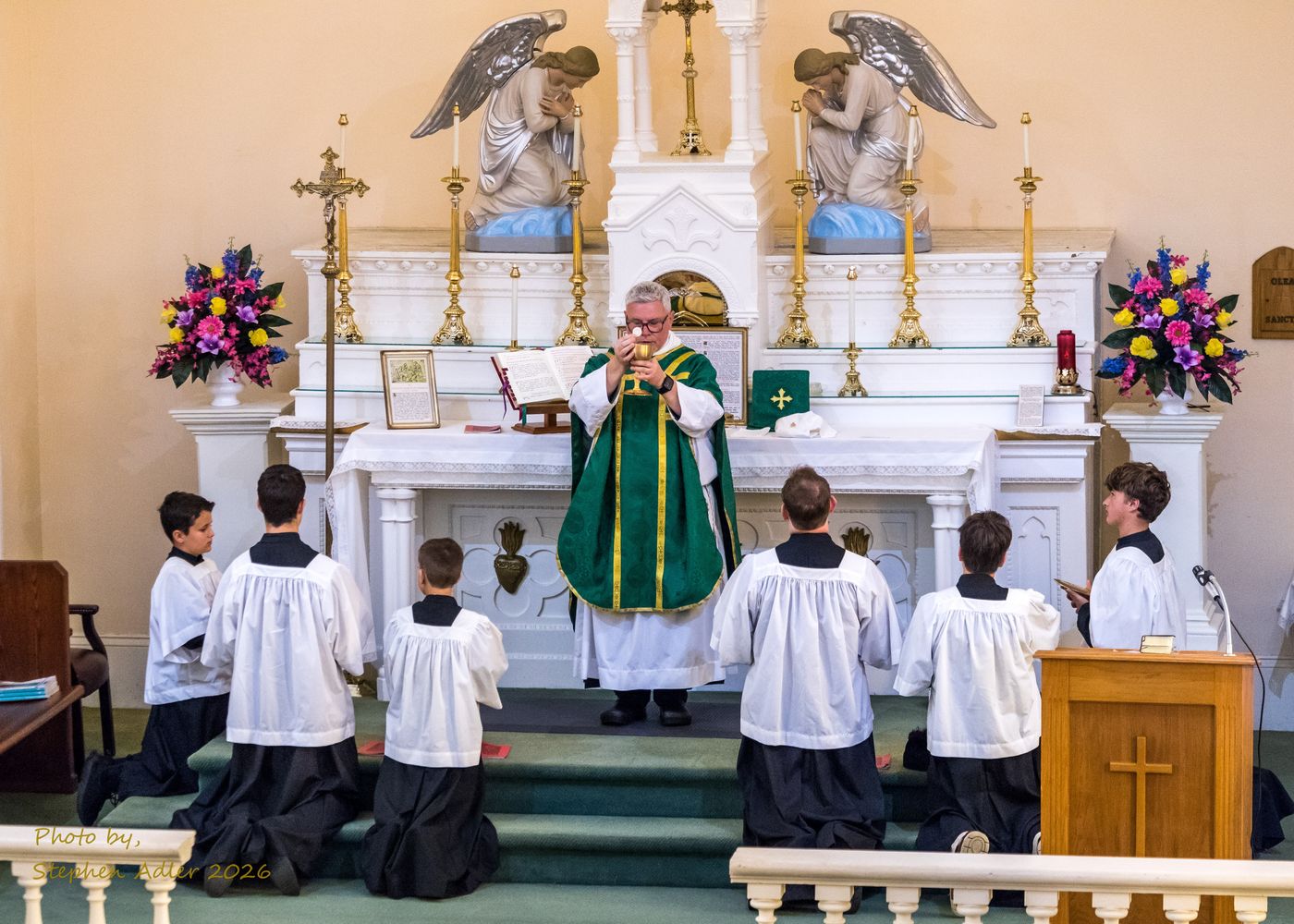 A priest at the altar with servers kneeling during the Traditional Latin Mass