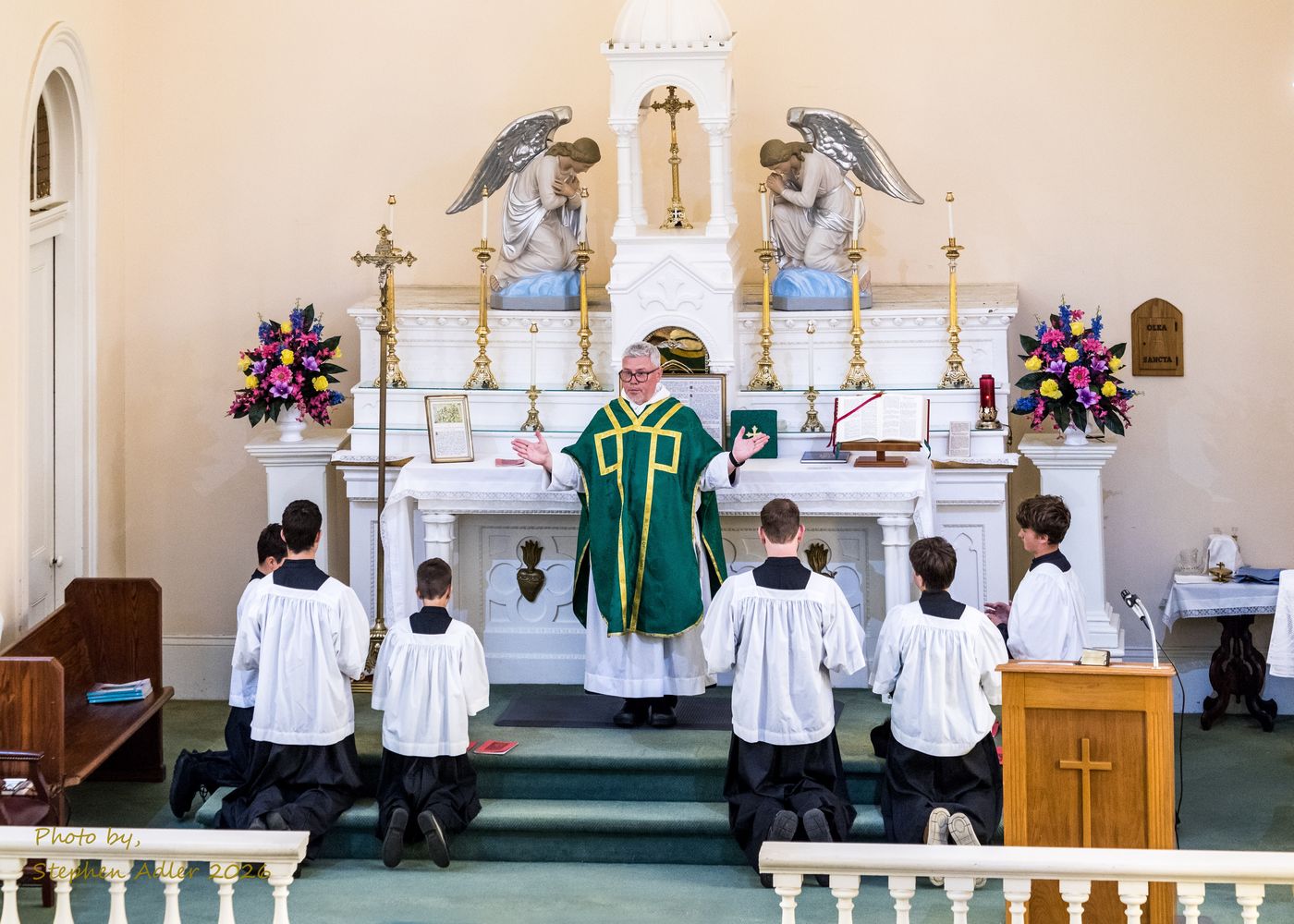 The priest and servers at the altar during Mass